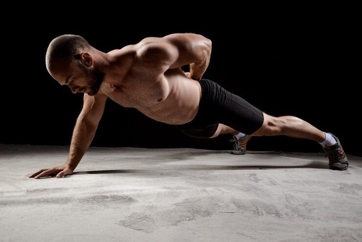 young_powerful_sportsman_training_push_ups_dark_wall_176420_540.jpg